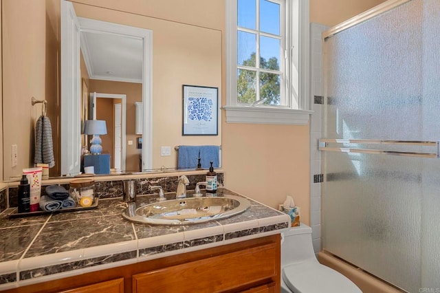 full bathroom featuring vanity, toilet, combined bath / shower with glass door, and crown molding