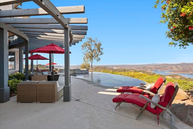 view of patio with a mountain view, an outdoor living space, and a pergola