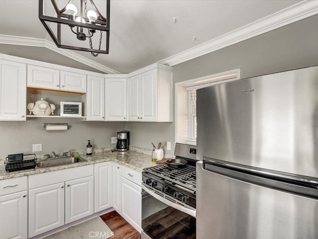 kitchen with lofted ceiling, sink, appliances with stainless steel finishes, and white cabinetry