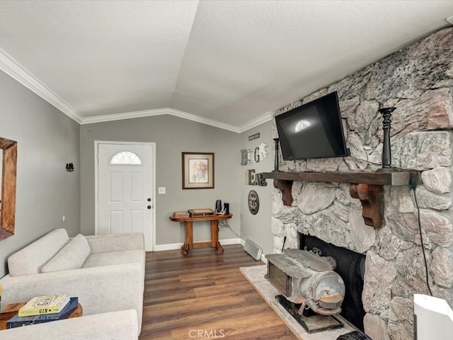 living room featuring a stone fireplace, crown molding, dark wood-type flooring, and vaulted ceiling