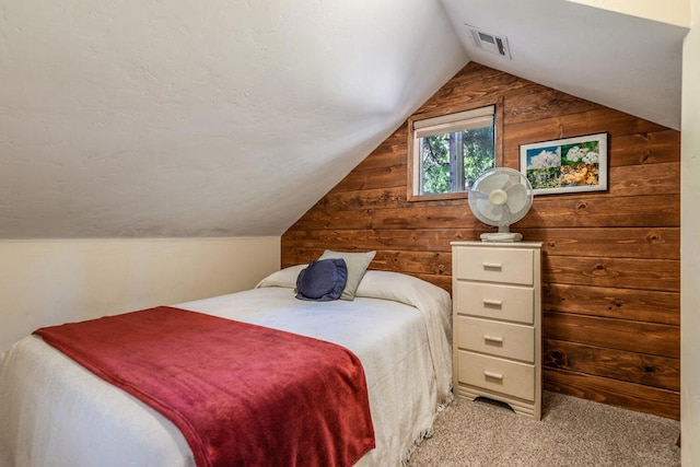 carpeted bedroom with lofted ceiling and wooden walls