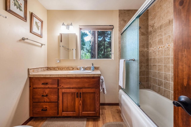 bathroom featuring vanity, wood-type flooring, and shower / bath combination with glass door