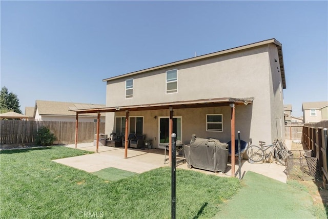 back of house featuring a lawn and a patio