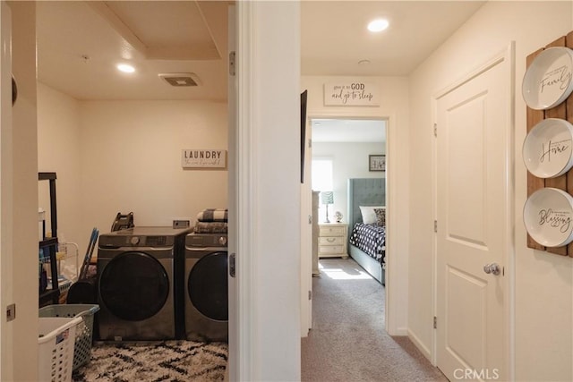 clothes washing area featuring washer and clothes dryer and light colored carpet