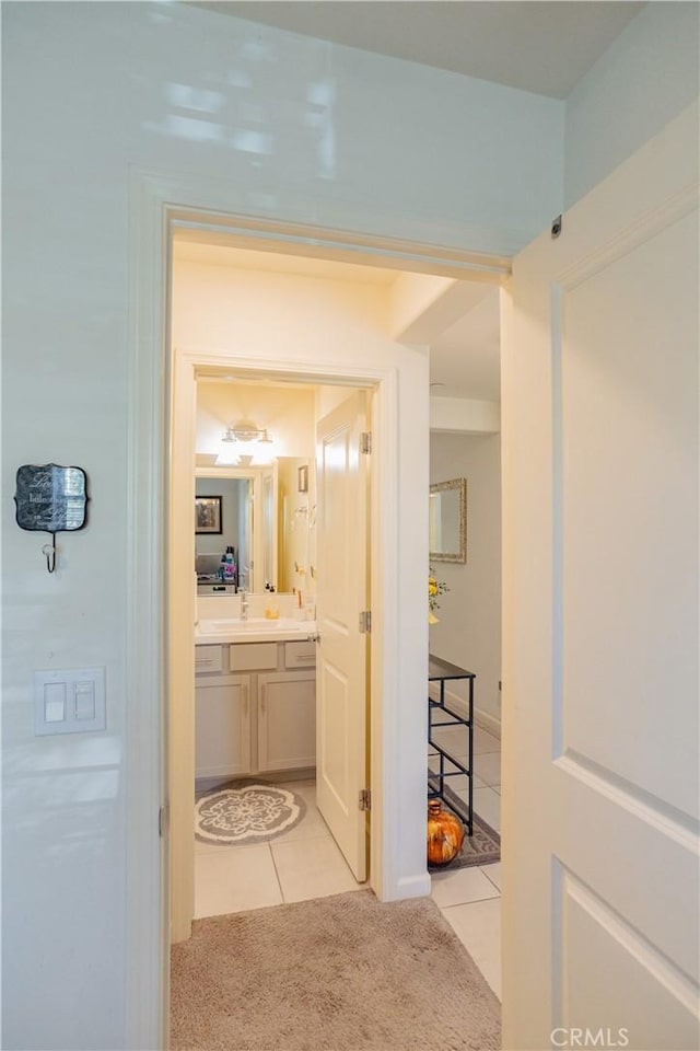 corridor with light colored carpet and sink