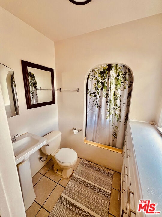 bathroom featuring toilet and tile patterned flooring