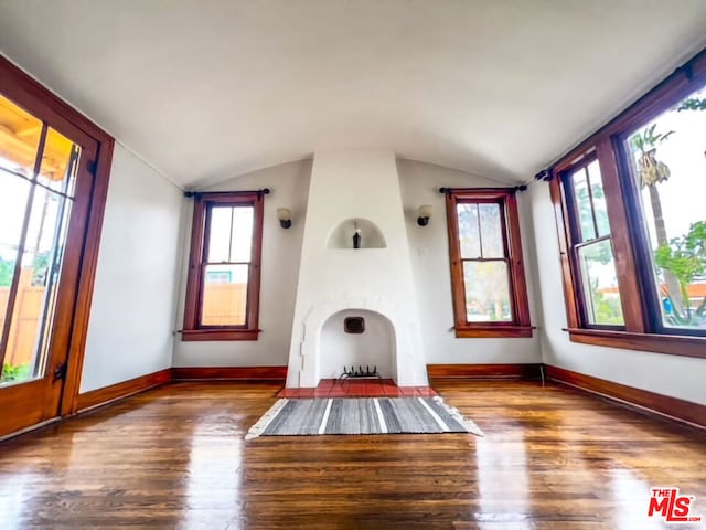 unfurnished living room with hardwood / wood-style floors, plenty of natural light, and vaulted ceiling