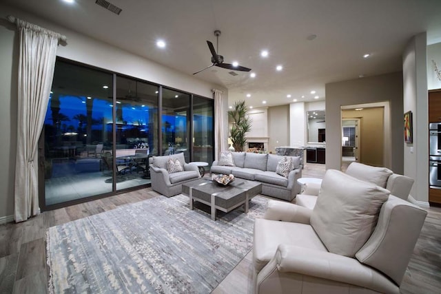 living room with wood-type flooring and ceiling fan