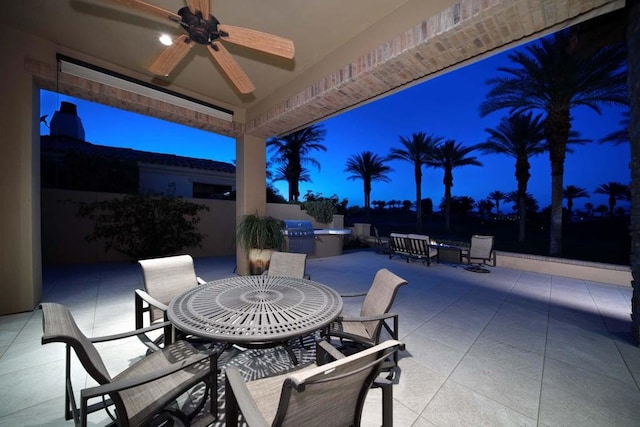 patio terrace at dusk with ceiling fan and grilling area