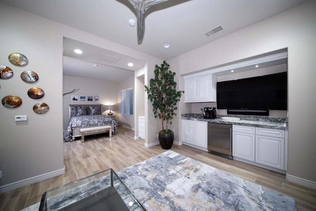 kitchen featuring light wood-type flooring, white cabinetry, dark stone countertops, and appliances with stainless steel finishes