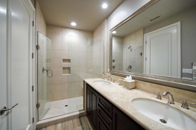 bathroom featuring vanity, wood-type flooring, and walk in shower