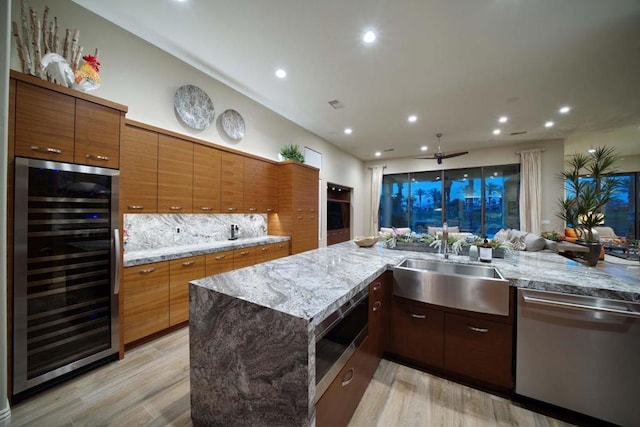 kitchen featuring light hardwood / wood-style floors, sink, stainless steel appliances, and wine cooler