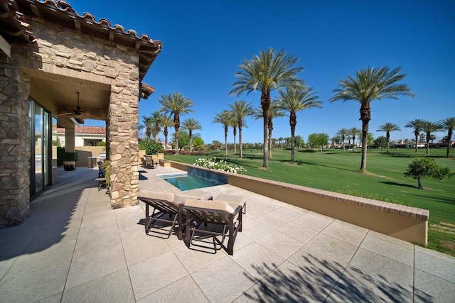 view of swimming pool featuring ceiling fan, a patio area, and a lawn