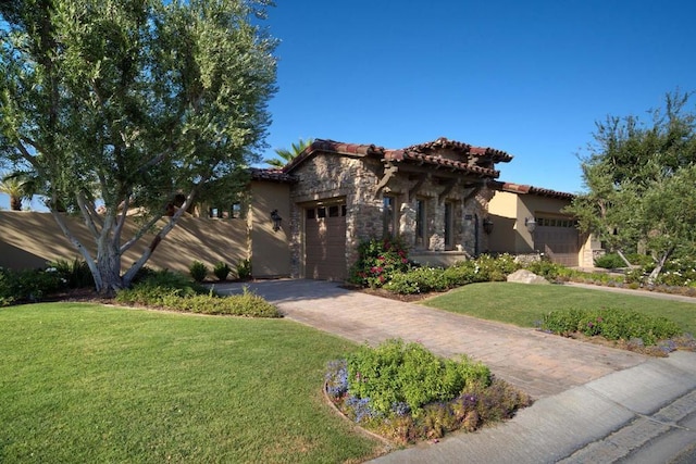 mediterranean / spanish home featuring a front yard and a garage