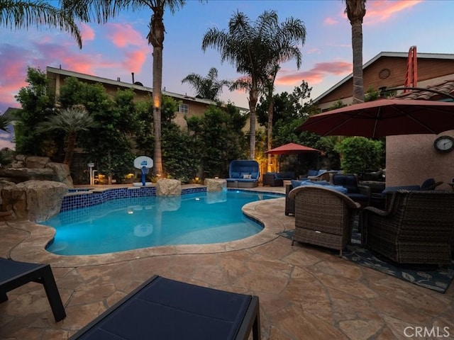 pool at dusk with a patio area