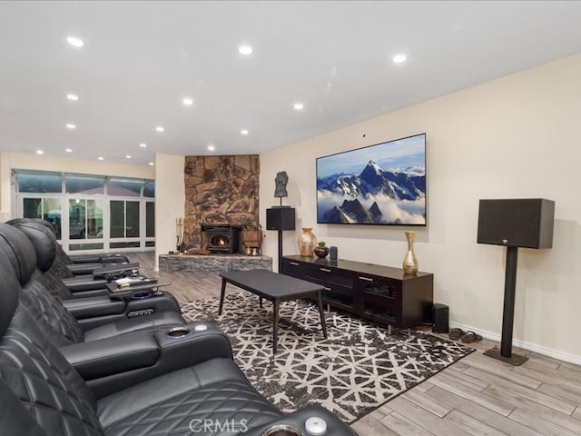 living room with light hardwood / wood-style floors and a wood stove