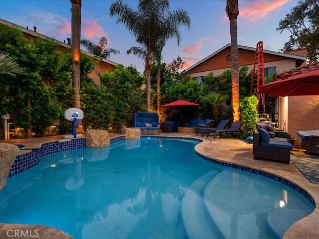 pool at dusk with a patio