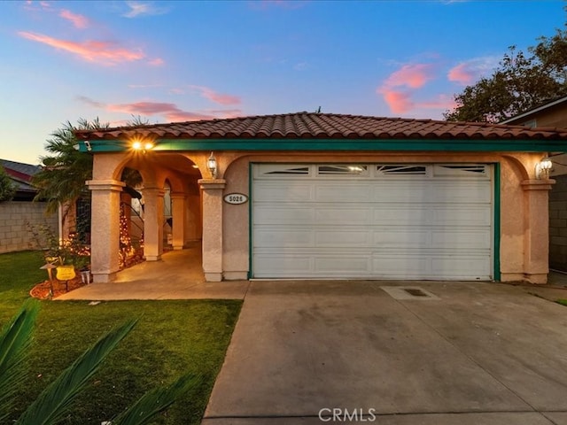 view of front of property featuring a garage and a lawn