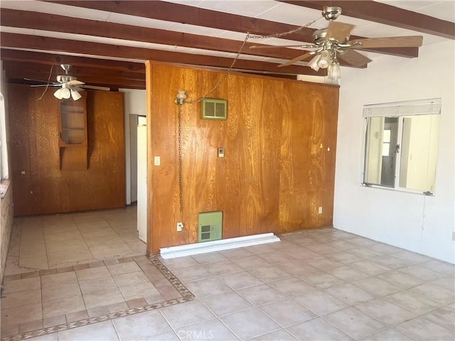 tiled spare room with ceiling fan, wood walls, and beam ceiling