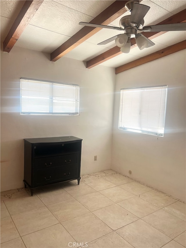 tiled empty room featuring a wealth of natural light, vaulted ceiling with beams, and ceiling fan