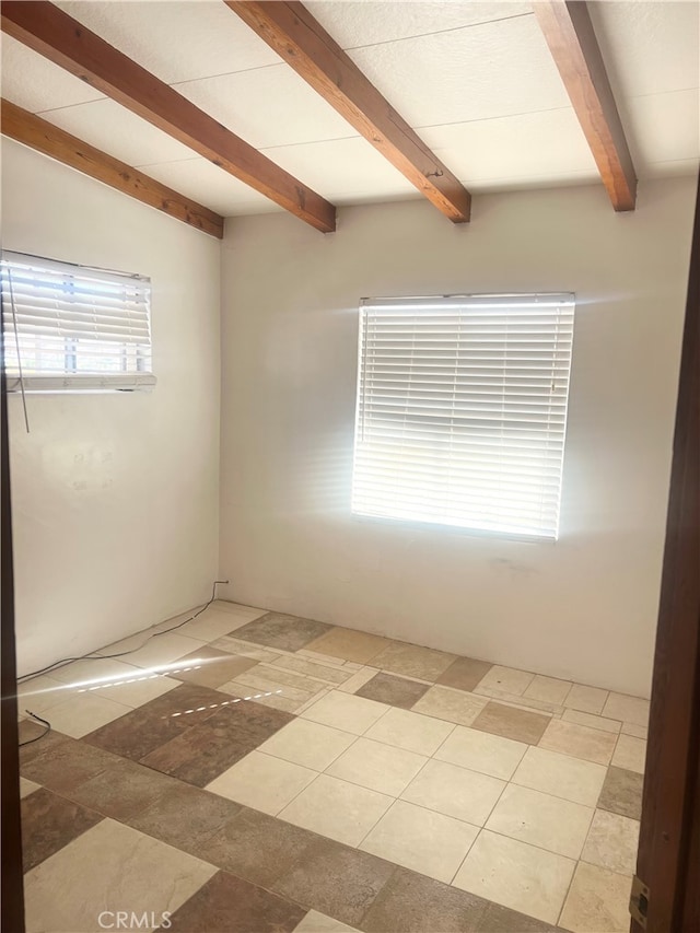 spare room featuring beam ceiling