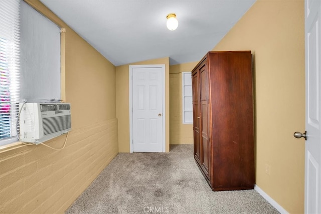 corridor featuring cooling unit, vaulted ceiling, and light carpet