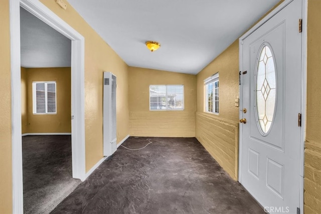 entrance foyer with lofted ceiling and brick wall