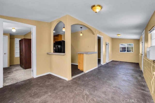 carpeted empty room with brick wall