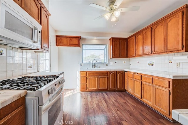 kitchen featuring sink, white appliances, dark wood-type flooring, ceiling fan, and decorative backsplash