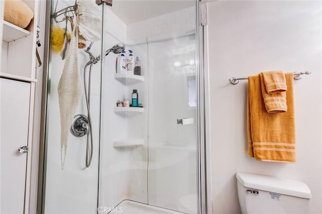 bathroom with an enclosed shower and toilet