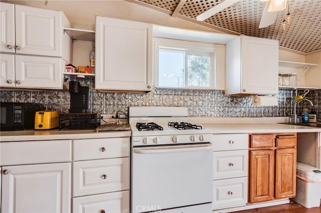 kitchen featuring tasteful backsplash, sink, white cabinets, and gas range gas stove