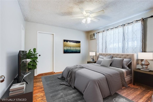 bedroom with ceiling fan, dark hardwood / wood-style floors, and a textured ceiling