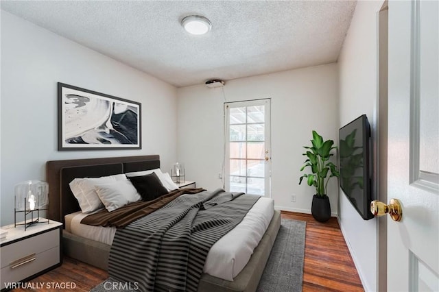 bedroom with dark wood-type flooring and a textured ceiling