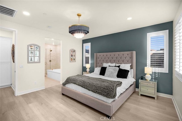 bedroom featuring light wood-type flooring and connected bathroom