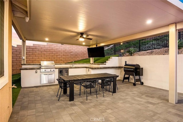 view of patio with area for grilling, ceiling fan, sink, and exterior kitchen