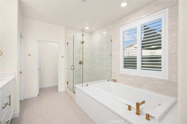 bathroom with tile patterned floors, vanity, and shower with separate bathtub