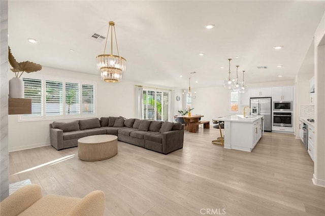 living room featuring sink and light hardwood / wood-style flooring