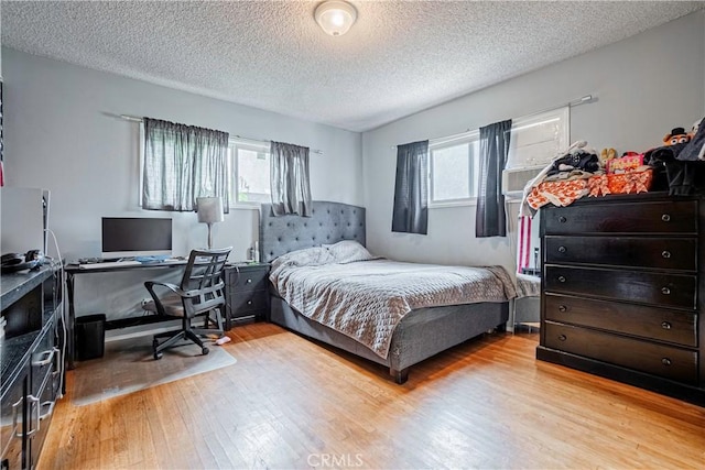 bedroom featuring light hardwood / wood-style floors and a textured ceiling