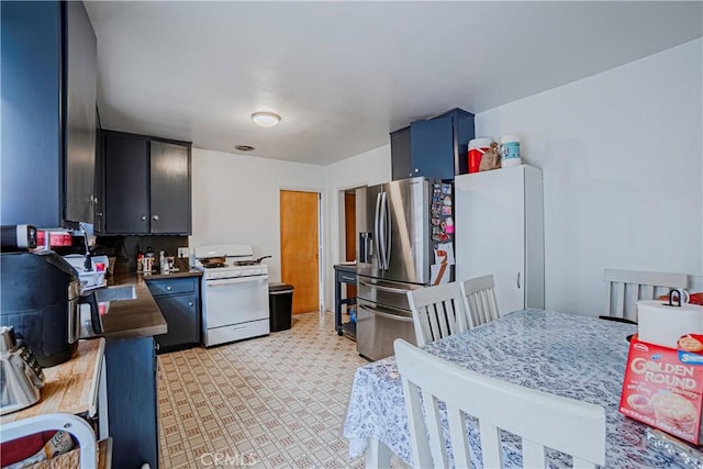 kitchen featuring blue cabinetry, white gas range oven, and stainless steel refrigerator with ice dispenser