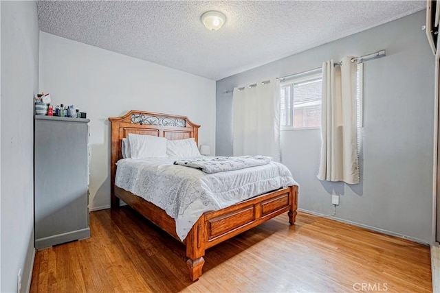 bedroom featuring wood-type flooring and a textured ceiling