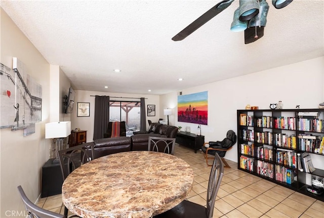 dining space featuring ceiling fan, light tile patterned floors, and a textured ceiling