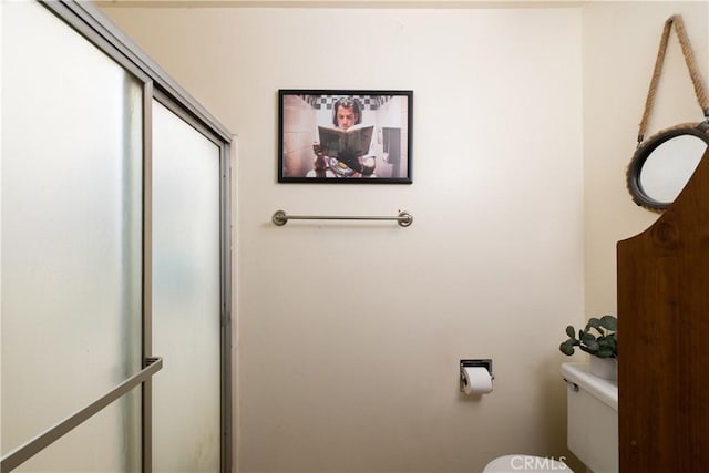 bathroom with toilet and a shower with shower door