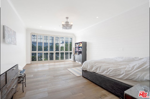 bedroom with a chandelier, crown molding, and light hardwood / wood-style floors