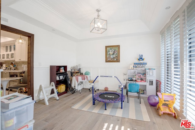 playroom with an inviting chandelier, plenty of natural light, and a raised ceiling