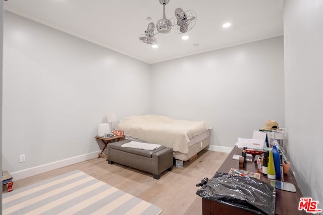 bedroom featuring ornamental molding and light hardwood / wood-style flooring