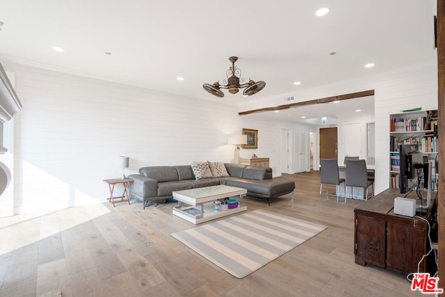 living room with crown molding, wooden walls, light wood-type flooring, and ceiling fan