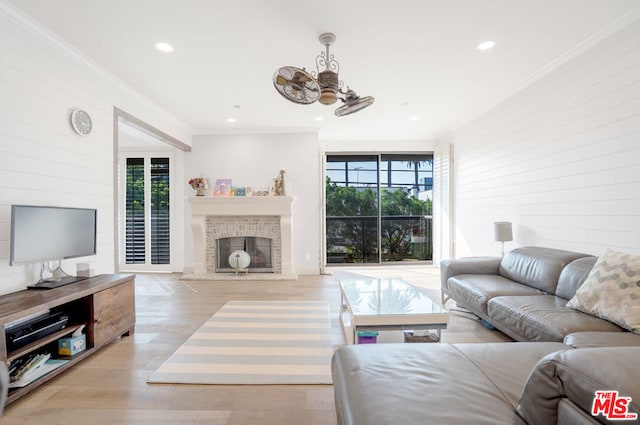 living room featuring ornamental molding, light hardwood / wood-style flooring, and a healthy amount of sunlight