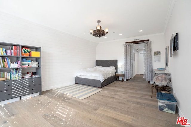 bedroom with ornamental molding, a notable chandelier, and wood-type flooring