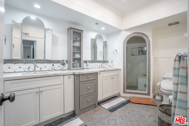 bathroom with backsplash, a shower with door, toilet, vanity, and tile patterned flooring