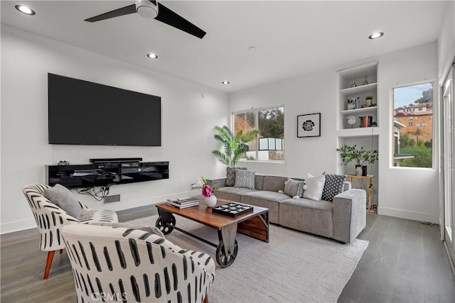 living room featuring ceiling fan, built in shelves, and wood-type flooring